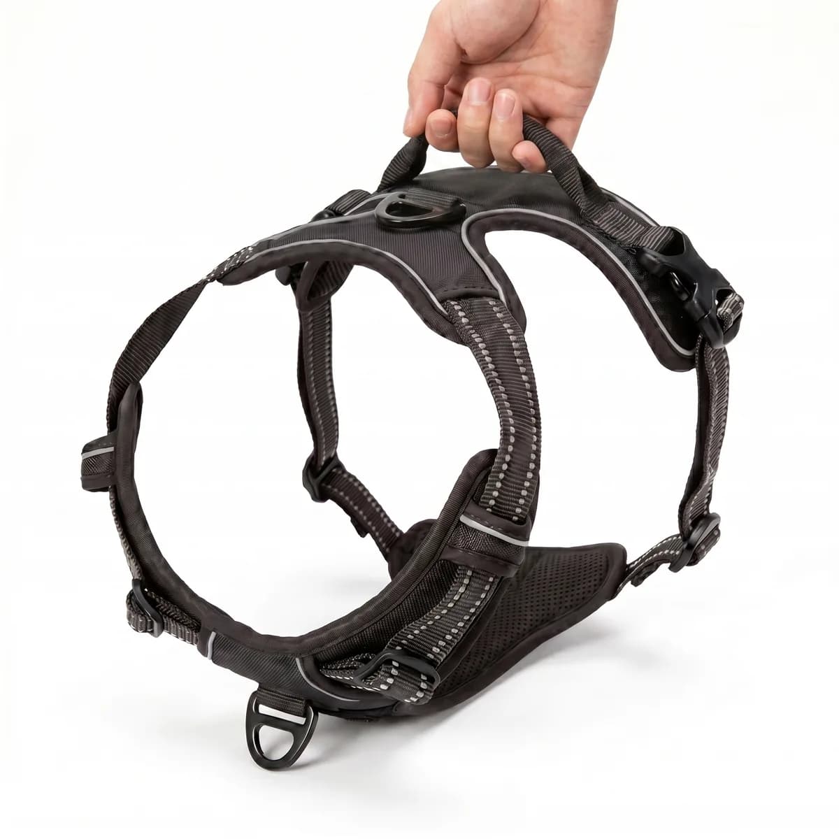 A hand holding the Dog Control Pro harness, showing the heavy-duty nylon webbing